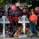 People gather at a memorial site to pay their respects for the victims killed in this week’s elementary school shooting in Uvalde, Texas, Thursday, May 26, 2022.